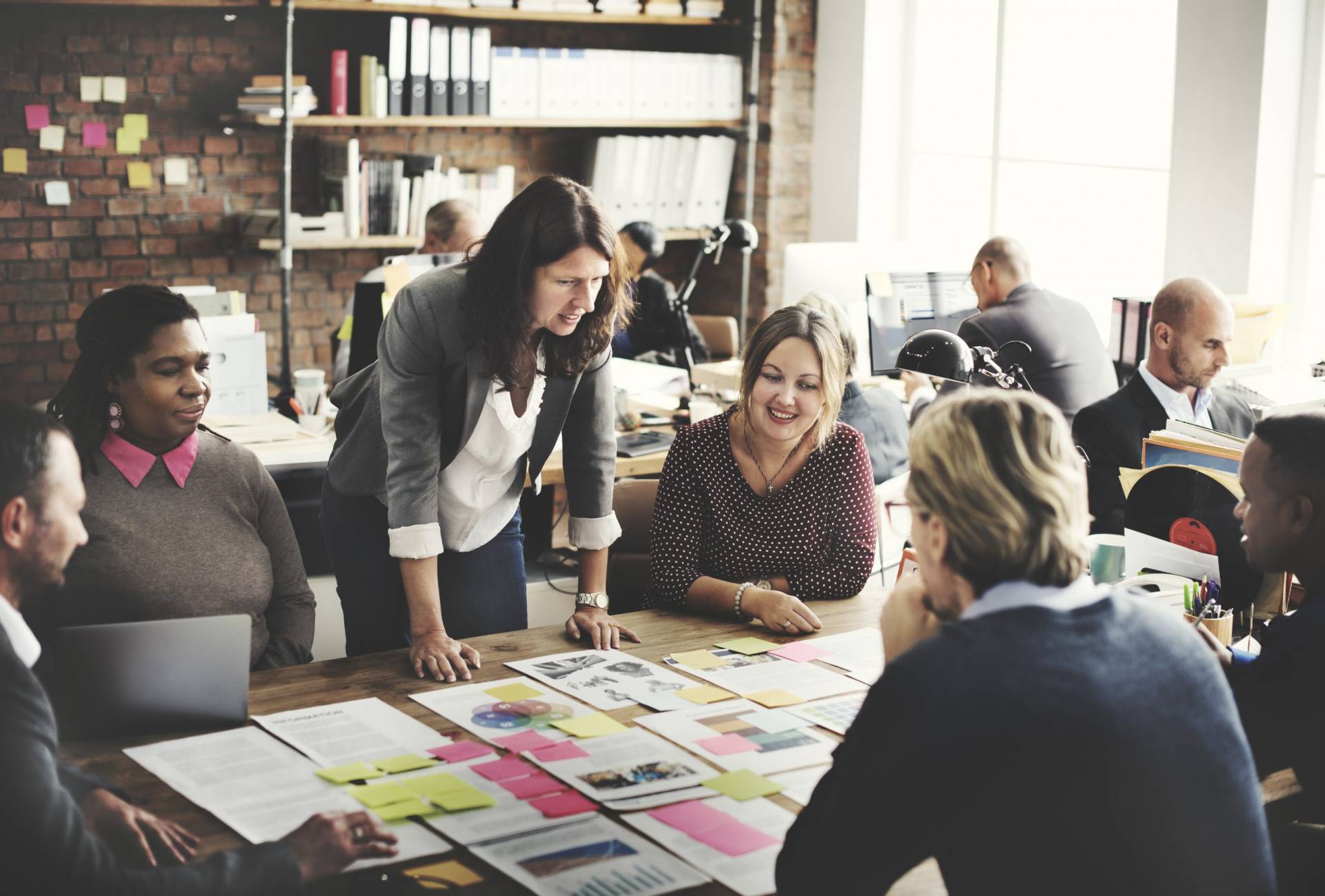 A team sits around a table, collaborating on a project